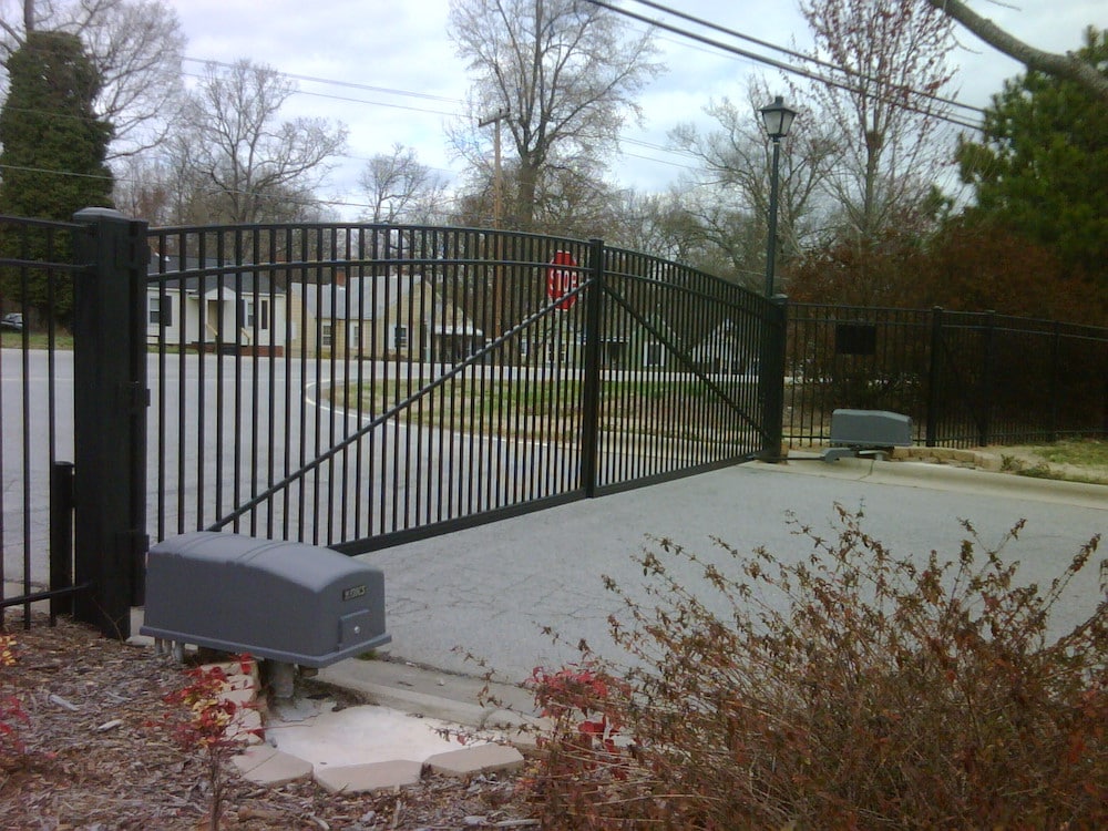 Large black gate entrance to a neighborhood - side view